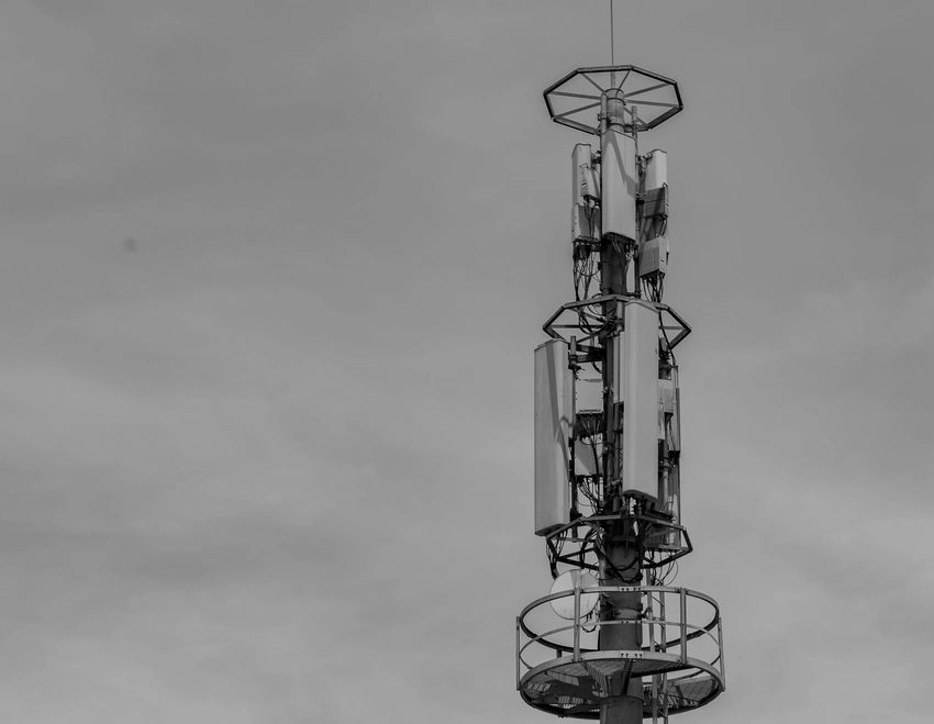 Antena de telefonía móvil contra un cielo despejado, en blanco y negro